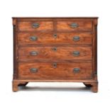 A George III mahogany chest of two short over three graduating drawers, the drawers flanked by