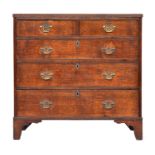 A George III oak chest of drawers, the top with reeded edge over two short and three graduating