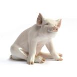 A Royal Copenhagen porcelain seated Pig, number 414, marked to base, 16cm high