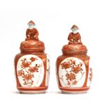 A pair of Japanese Kutani vases, decorated with floral panels, each with figural finial to lid,