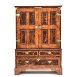 A George I figured oak cabinet on stand, with mulberry panels, the cabinet doors opening to an
