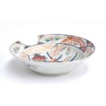 A 19th century Japanese Imari shaving bowl, with central floral urn decoration, heightened in