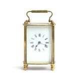 A French gilt metal carriage clock with bevelled glass, enamel dial with Roman numerals, 14.5cm high