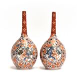 A pair of Japanese imari bottle vases, decorated with interlocking florals surrounding a central