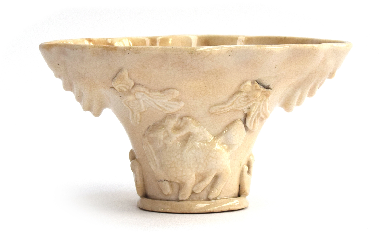 A Chinese blanc de chine libation cup, Fukien province, modelled in the rhinoceros horn form, with