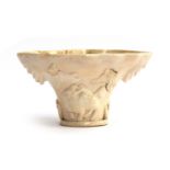 A Chinese blanc de chine libation cup, Fukien province, modelled in the rhinoceros horn form, with