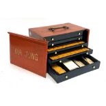 A red lacquered japanned Mahjong set with sliding front, opening to 5 drawers, marked Chang Seng