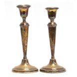 A pair of silver candlesticks by William Hutton & Sons Ltd, Birmingham 1916 (loaded), of tapered