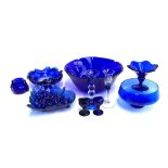 A mixed lot of blue glass to include blue glass pebbles; fruit bowl; candle sticks; eye baths etc