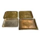 Three Islamic brass trays; together with one other