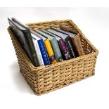 A number of Jamie Oliver cookbooks and others in a wicker basket