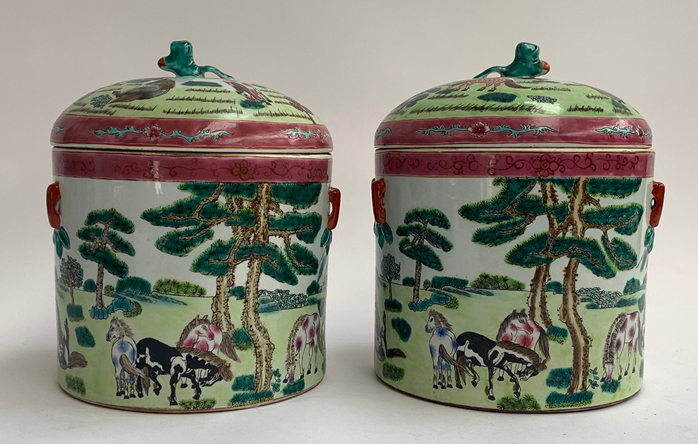 A pair of Chinese famille rose lidded pots depicting horses is a mountainous landscape, each with