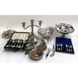 A mixed lot of plated items to include two swing handled baskets; a three arm candlestick holder;