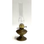 A copper and brass oil lamp with glass chimney