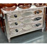 A modern limed effect chest of three drawers, with mirrored top and sides, the drawer fronts with