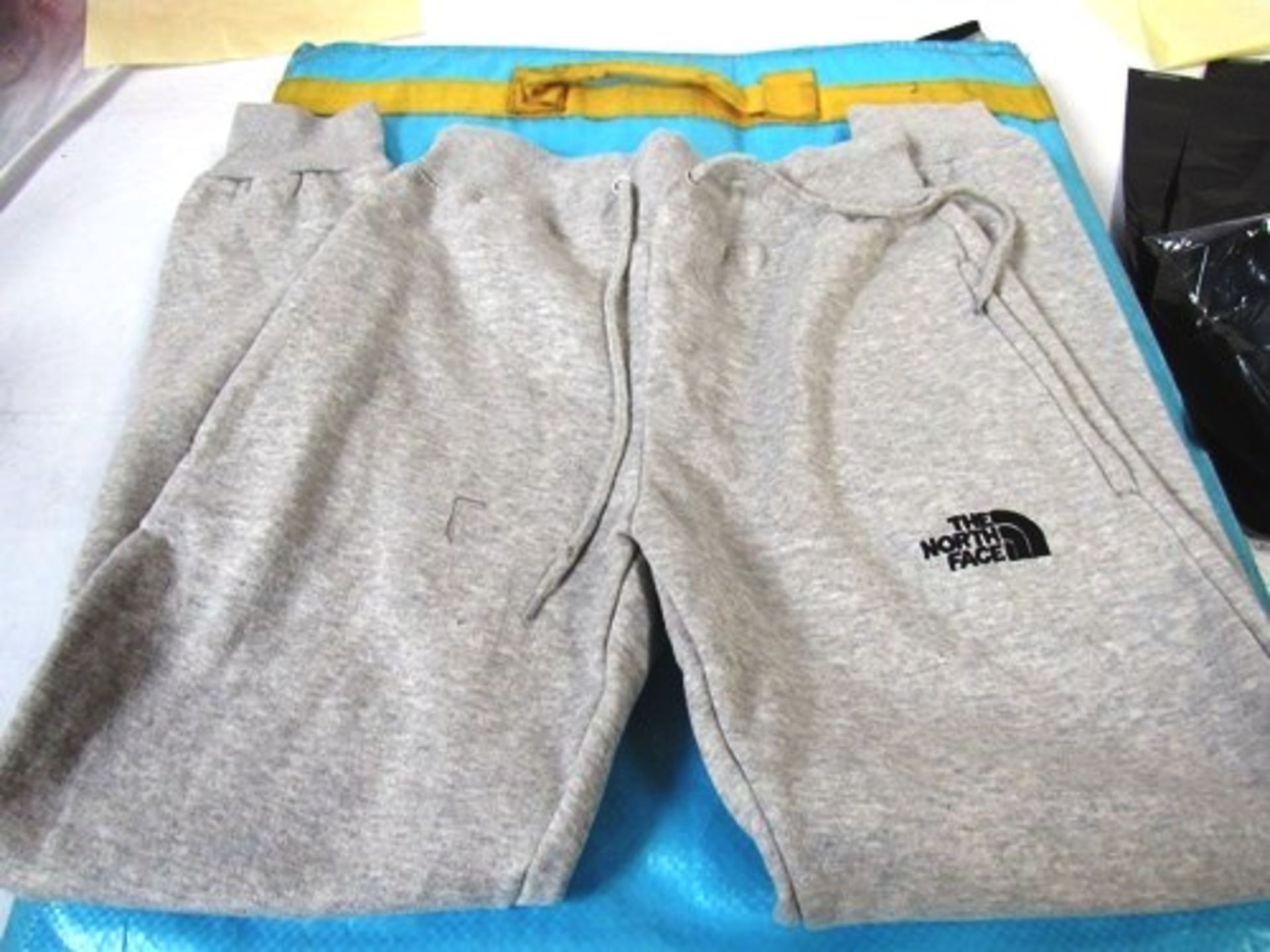 Approximately 20 x pieces of clothing in the style of North Face brand, sweatshirts and joggers,