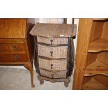 A wicker bombe shaped chest of four graduated draw