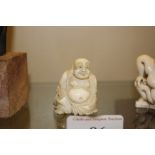 A carved ivory Netsuke in the form of a seated Bud