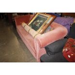 A pink upholstered velvet settee