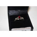 A boxed silver and red stone set ring