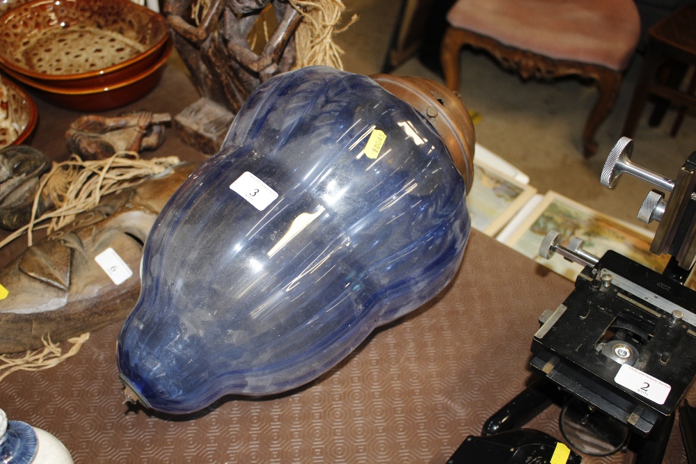 A large blue glass ceiling light