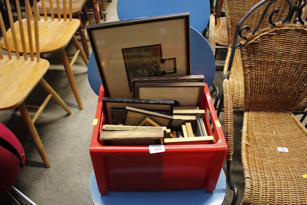 A plastic crate containing small pictures and prin