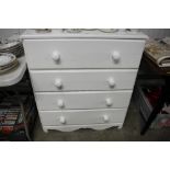 A modern chest painted white fitted four long draw