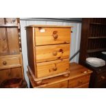 A stripped pine bedside chest fitted three drawers