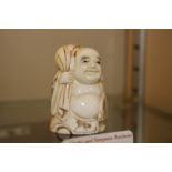 A carved ivory Netsuke in the form of a figure car