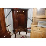 An antique oak corner cupboard on stand