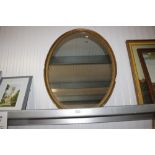 A gilt framed oval wall mirror