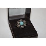 A silver and turquoise set filigree work ring