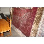 An approx. 10'4" x 6'10" Eastern red patterned rug