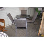 A metal and glass garden table with four chairs