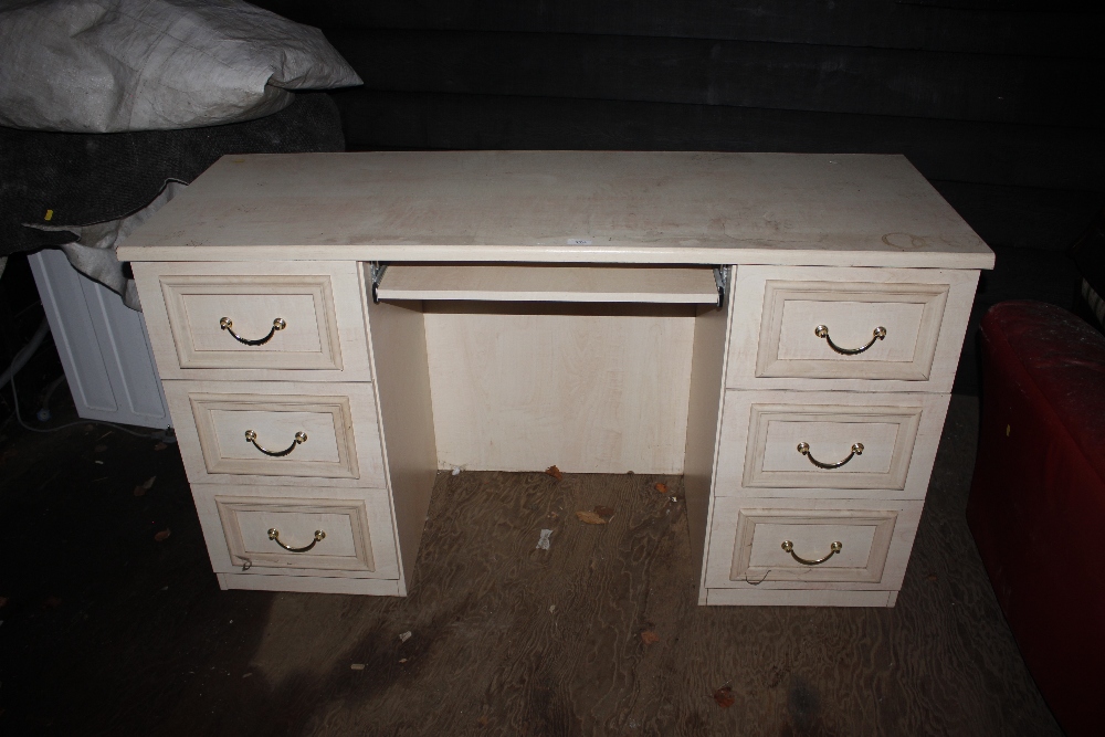 A beech effect knee hole desk fitted six drawers