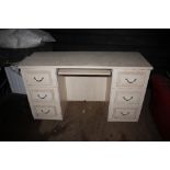 A beech effect knee hole desk fitted six drawers