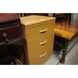 A pine effect three drawer bedside chest