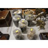Five glass storage jars and contents of various se
