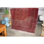 An approx. 10'4" x 6'10" Eastern red patterned rug