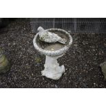 A pre cast dove and squirrel decorated bird bath