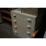 A white painted chest of drawers and a child's cha
