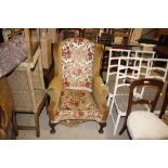 A wing back armchair on cabriole supports