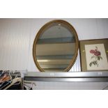 A gilt framed oval wall mirror