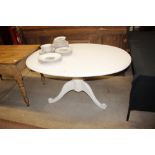 A white painted oval topped dining table