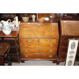 An antique oak bureau fitted two short and three l