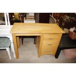 A modern light wood single pedestal desk fitted th