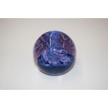A mauve and blue tinted glass paperweight