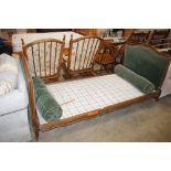 A French green upholstered single bed with cushions