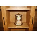 A brass cased mantel clock with presentation inscr