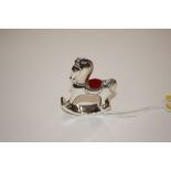 A silver rocking horse pin cushion